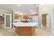 Spacious kitchen features an island, wood cabinets, and white appliances at 997 Nash Loop, The Villages, FL 32162