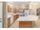 A well-lit kitchen with stone counters, white appliances, and wood cabinets at 997 Nash Loop, The Villages, FL 32162