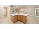 Bright kitchen island with white countertop, and access to multiple rooms at 997 Nash Loop, The Villages, FL 32162