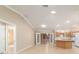 Open-concept living area flows into kitchen, featuring tile flooring, crown molding, and natural light at 997 Nash Loop, The Villages, FL 32162