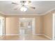 Large open living room with crown molding and natural light at 997 Nash Loop, The Villages, FL 32162