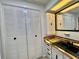 A bathroom featuring a custom vanity with a black sink, cabinet storage and convenient closet for a serene, efficient space at 105 Temple W Cv, Leesburg, FL 34748