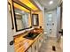 Bathroom featuring a wood countertop, black sink, storage and lighted ceiling at 105 Temple W Cv, Leesburg, FL 34748