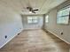 Spacious bedroom with wood flooring, multiple windows and a ceiling fan at 105 Temple W Cv, Leesburg, FL 34748