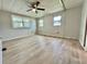 Spacious bedroom with wood flooring, multiple windows and a ceiling fan at 105 Temple W Cv, Leesburg, FL 34748
