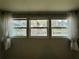 Bedroom windows offer a view of the water with sheer white curtains at 105 Temple W Cv, Leesburg, FL 34748