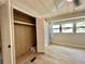 Bedroom view showcasing wood flooring, closet and three windows with curtains at 105 Temple W Cv, Leesburg, FL 34748
