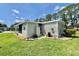 Well-maintained home exterior with manicured landscaping, including green grass, shrubs, and exterior utilities at 105 Temple W Cv, Leesburg, FL 34748