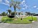 Inviting home showcasing a manicured lawn, complemented by mature trees and vibrant landscaping at 105 Temple W Cv, Leesburg, FL 34748