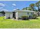 Well-maintained home exterior with neat landscaping, including green grass, shrubs, and exterior utilities at 105 Temple W Cv, Leesburg, FL 34748