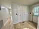 Hallway leads past double-door closet with wood-look flooring and neutral walls at 105 Temple W Cv, Leesburg, FL 34748
