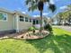 Well-maintained home with appealing landscaping, featuring decorative rocks, accent lighting, and vibrant green grass at 105 Temple W Cv, Leesburg, FL 34748
