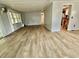 Open living room showcases wood-look flooring, and access to kitchen and sunroom at 105 Temple W Cv, Leesburg, FL 34748