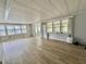 Bright living room with large windows providing plenty of natural light and wood-look floors at 105 Temple W Cv, Leesburg, FL 34748