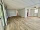 Living room features wood-look flooring, a ceiling fan, and access to the sunroom at 105 Temple W Cv, Leesburg, FL 34748