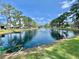 Lovely community pond featuring a fountain, surrounded by lush green lawns and trees at 105 Temple W Cv, Leesburg, FL 34748