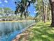 Scenic view of a community pond with lush landscaping and fountain at 105 Temple W Cv, Leesburg, FL 34748
