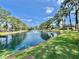 Beautiful pond with fountain, framed by mature trees and a manicured lawn at 105 Temple W Cv, Leesburg, FL 34748