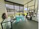 Comfortable screened-in porch with table, chairs, and golf cart at 105 Temple W Cv, Leesburg, FL 34748