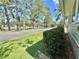 Picturesque street view with mature trees, a tranquil pond, and a charming home in the background at 105 Temple W Cv, Leesburg, FL 34748
