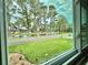 This window offers a picturesque view of a tranquil pond, complemented by lush greenery and a serene waterscape at 105 Temple W Cv, Leesburg, FL 34748