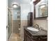 Bathroom featuring a marble sink, dark wood vanity, framed mirror and walk-in shower at 1113 Elkhart Cir, Tavares, FL 32778