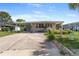 Exterior view of the residence with a covered carport, well-maintained lawn, and landscaping at 1113 Elkhart Cir, Tavares, FL 32778