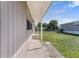 Side exterior view of the home showcasing a walkway, lawn, and covered porch at 1113 Elkhart Cir, Tavares, FL 32778