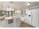 Bright kitchen boasts white appliances, cabinetry, and a convenient center island at 1113 Elkhart Cir, Tavares, FL 32778