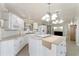 Well-lit kitchen featuring white cabinets, an island cooktop, and modern appliances at 1113 Elkhart Cir, Tavares, FL 32778