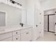 Bright bathroom featuring a double vanity with a white countertop and framed mirror, complemented by a glass-door shower at 1191 Stratton Ave, Groveland, FL 34736