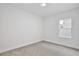 Bedroom with neutral carpet, baseboards, white walls, and a single window at 1191 Stratton Ave, Groveland, FL 34736