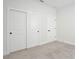 Bedroom with neutral carpet, baseboards, white walls, and a closet with sliding doors at 1191 Stratton Ave, Groveland, FL 34736