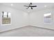 Bright bedroom with neutral carpet, ceiling fan, and a view to the outside at 1191 Stratton Ave, Groveland, FL 34736