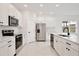 Modern kitchen featuring white cabinets, stainless steel appliances, and quartz countertops at 1191 Stratton Ave, Groveland, FL 34736