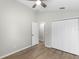 Bedroom features wood-look floors, a ceiling fan, and neutral-painted walls at 12838 Owasso Ln, Clermont, FL 34711