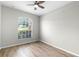 Well-lit bedroom with vaulted ceilings, wood floors, and a large window, creating a bright and airy space at 12838 Owasso Ln, Clermont, FL 34711