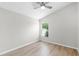 Bedroom features wood-look floors, a window view, and neutral-painted walls at 12838 Owasso Ln, Clermont, FL 34711