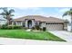 Well-maintained home exterior with lush landscaping and a two-car garage at 12838 Owasso Ln, Clermont, FL 34711