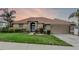 Charming single-story home featuring a well-manicured lawn, mature trees, and an attached two-car garage at 12838 Owasso Ln, Clermont, FL 34711