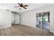 Main bedroom with wood floors, a ceiling fan, and sliding glass doors to a patio, offering a relaxing retreat at 12838 Owasso Ln, Clermont, FL 34711