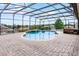 Relaxing pool area with a waterfall feature, hot tub, and a screened-in enclosure at 12838 Owasso Ln, Clermont, FL 34711