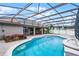 Relaxing screened-in pool area featuring a hot tub and stylish pavers at 12838 Owasso Ln, Clermont, FL 34711