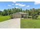 Charming single-story home featuring lush landscaping and a two-car garage at 12952 Del Lago Dr, Astatula, FL 34705