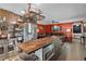 A modern kitchen with stainless steel appliances that opens to a living room with an orange wall at 12952 Del Lago Dr, Astatula, FL 34705