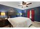 Stylish main bedroom featuring a blue accent wall, wood furniture, and cozy ambiance at 12952 Del Lago Dr, Astatula, FL 34705
