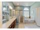 Bright bathroom featuring a walk-in shower, garden tub and a large vanity with storage at 13100 Lakewind Dr, Clermont, FL 34711