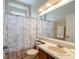 Bathroom featuring a single sink vanity with tile flooring and a shower with patterned curtains at 13100 Lakewind Dr, Clermont, FL 34711