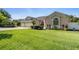 Charming home with a lush green lawn, beautiful landscaping, and a three-car garage at 13100 Lakewind Dr, Clermont, FL 34711