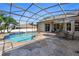 This beautiful screened-in pool comes with an umbrella and dining furniture on the patio at 13100 Lakewind Dr, Clermont, FL 34711